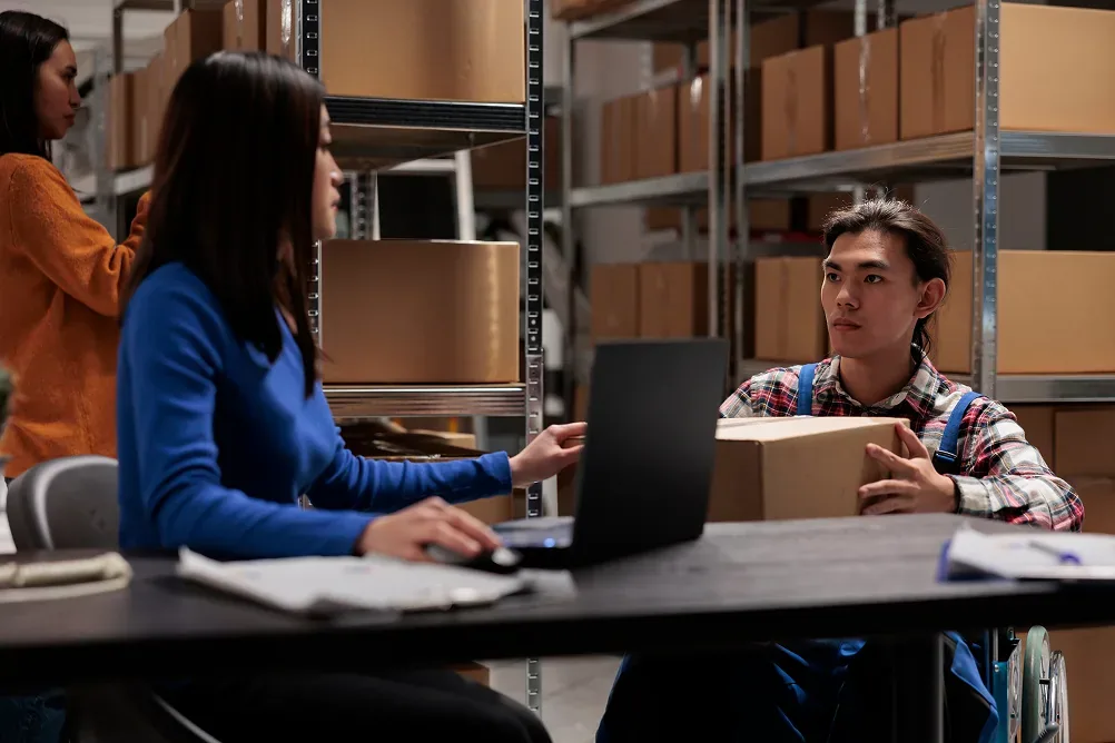 Warehouse staff managing orders and deliveries with route and order management software.